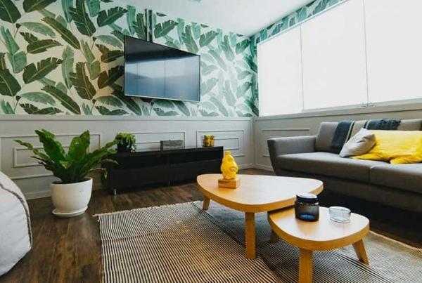 Σαλόνι σπιτιού με καναπέ , 2 τραπεζάκια , και τηλεόραση στον τοίχο